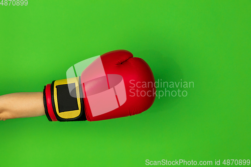 Image of Hand in boxing red glove isolated on green studio background with copyspace.