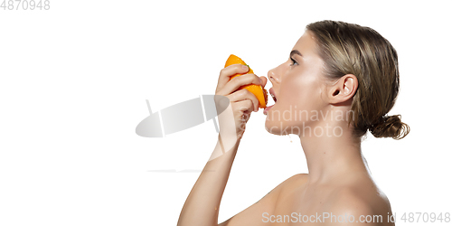 Image of Energy. Close up of beautiful young woman biting juicy orange over white background. Cosmetics and makeup, natural and eco treatment, skin care. Flyer, proposal.