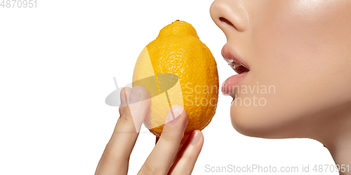 Image of Freshness. Close up of beautiful young woman biting juicy lemon over white background. Cosmetics and makeup, natural and eco treatment, skin care. Flyer, proposal.