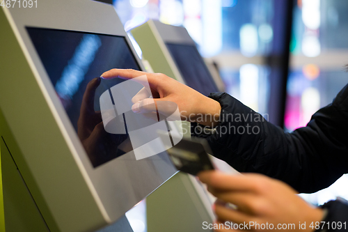 Image of Woman using credit card to pay on the automatic cinema ticketing