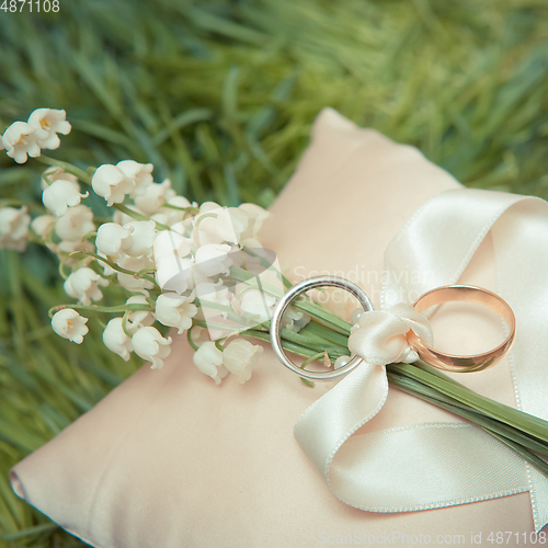 Image of white gold wedding rings with a bouquet 