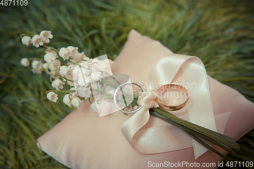 Image of white gold wedding rings with a bouquet 