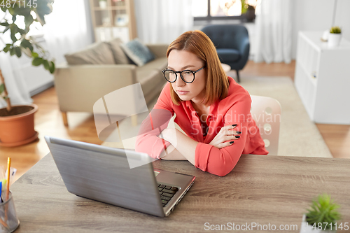 Image of bored woman with laptop working at home office