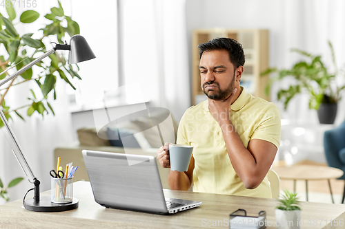 Image of sick indian man with sore throat working at home