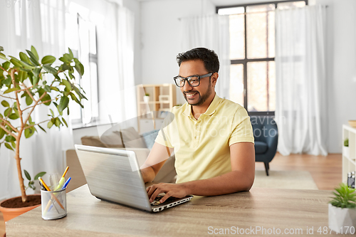 Image of indian man with laptop working at home office