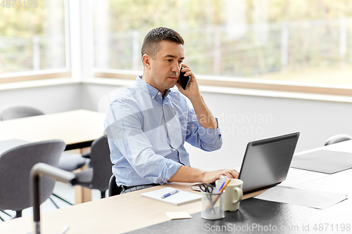 Image of man calling on smartphone at home office