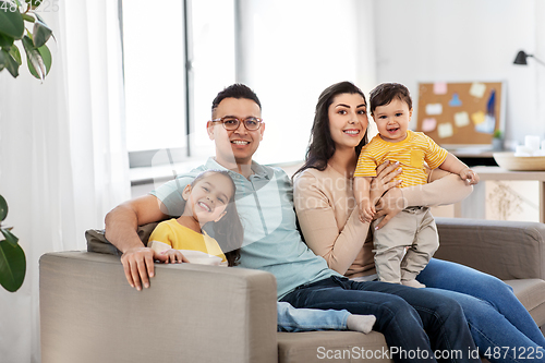 Image of portrait of happy family sitting on sofa at home