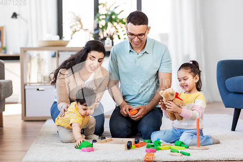 Image of happy family palying with wooden toys at home