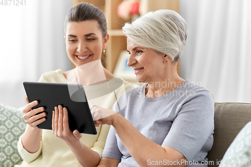 Image of daughter and senior mother with tablet pc at home