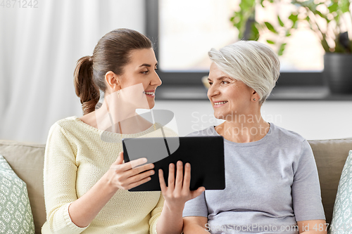 Image of daughter and senior mother with tablet pc at home