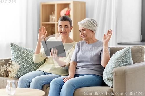 Image of daughter and mother having video call on tablet pc