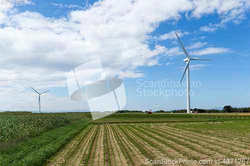 Image of Wind turbine and farm with blue sky