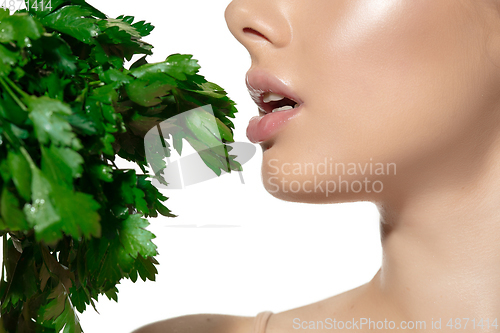 Image of Fresh. Close up of beautiful young woman with green leaves over white background. Cosmetics and makeup, natural and eco treatment, skin care