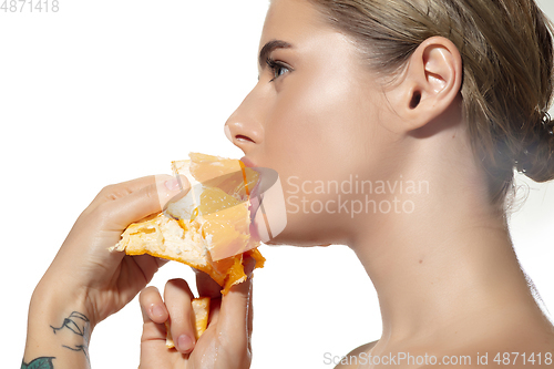 Image of Energy. Close up of beautiful young woman biting juicy orange over white background. Cosmetics and makeup, natural and eco treatment, skin care.