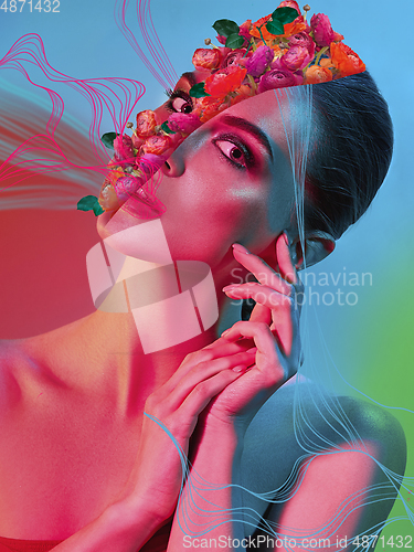 Image of Portrait of beautiful young woman with modern floral design, inspiration artwork. Fashion, beauty concept. Neon light.