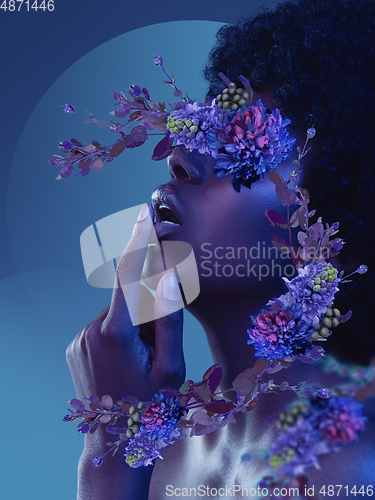 Image of Portrait of beautiful young woman with modern floral design, inspiration artwork. Fashion, beauty concept. Neon light.