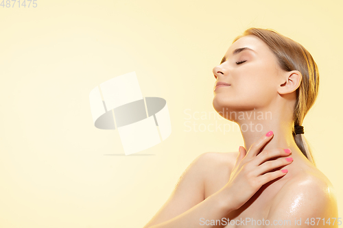 Image of Tender skin. Close up of beautiful woman with moisturizer over yellow background. Cosmetics and makeup, natural and eco treatment, skin care.