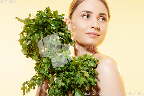 Image of Fresh. Close up of beautiful female face with green leaves over white background. Cosmetics and makeup, natural and eco treatment, skin care.