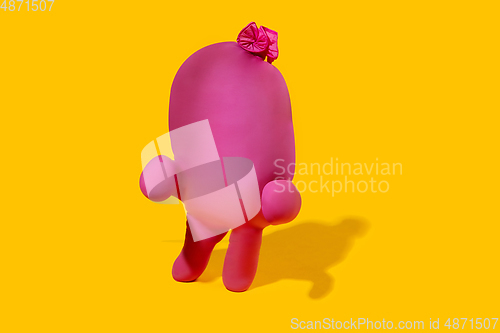 Image of Life of rubber glove like a person - protective wear isolated on yellow studio background