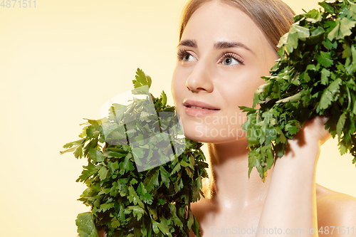 Image of Fresh. Close up of beautiful female face with green leaves over white background. Cosmetics and makeup, natural and eco treatment, skin care.