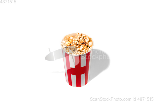 Image of Striped white red bucket full of popcorn isolated on white studio background with copyspace