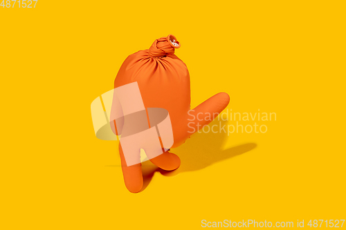 Image of Life of rubber glove like a person - protective wear isolated on yellow studio background