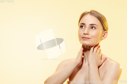 Image of Tender skin. Close up of beautiful woman with moisturizer over yellow background. Cosmetics and makeup, natural and eco treatment, skin care.