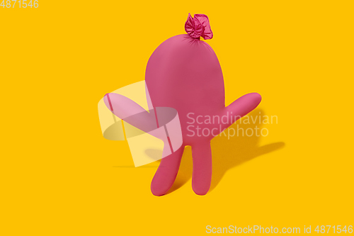 Image of Life of rubber glove like a person - protective wear isolated on yellow studio background