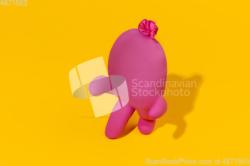 Image of Life of rubber glove like a person - protective wear isolated on yellow studio background