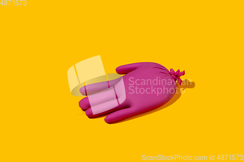Image of Life of rubber glove like a person - protective wear isolated on yellow studio background