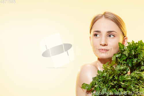 Image of Fresh. Close up of beautiful female face with green leaves over white background. Cosmetics and makeup, natural and eco treatment, skin care.