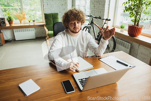 Image of Manager or student working from home while being insulated or keep quarantine \'cause of coronavirus COVID-19. Making notes.