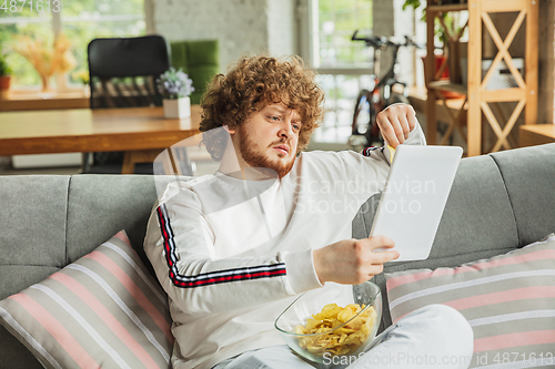 Image of Manager or student working from home while being insulated or keep quarantine \'cause of coronavirus COVID-19. Reading report, task, sitting on sofa.