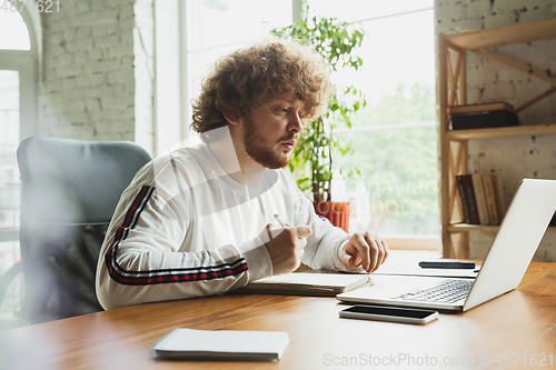 Image of Manager or student working from home while being insulated or keep quarantine \'cause of coronavirus COVID-19. Making notes.