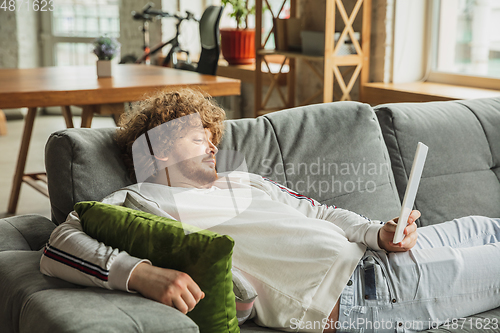 Image of Manager or student working from home while being insulated or keep quarantine \'cause of coronavirus COVID-19. Reading report, task, sitting on sofa.