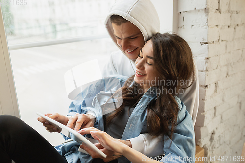 Image of Quarantine lockdown, stay home concept - young beautiful caucasian couple enjoying new lifestyle during coronavirus worldwide health emergency