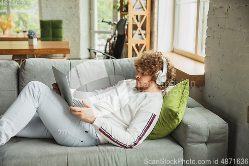 Image of Manager or student working from home while being insulated or keep quarantine \'cause of coronavirus COVID-19. Working lying down on sofa.