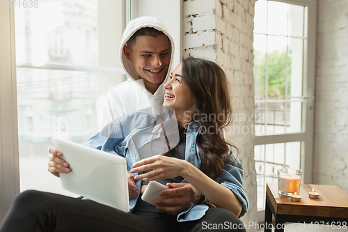 Image of Quarantine lockdown, stay home concept - young beautiful caucasian couple enjoying new lifestyle during coronavirus worldwide health emergency