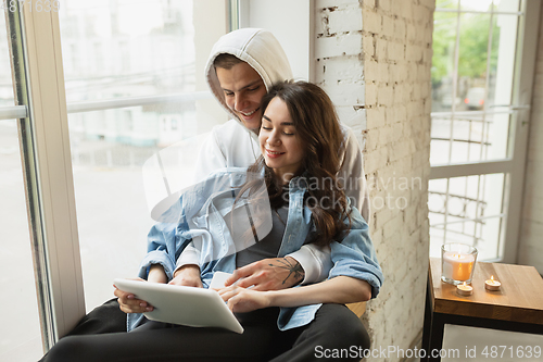 Image of Quarantine lockdown, stay home concept - young beautiful caucasian couple enjoying new lifestyle during coronavirus worldwide health emergency