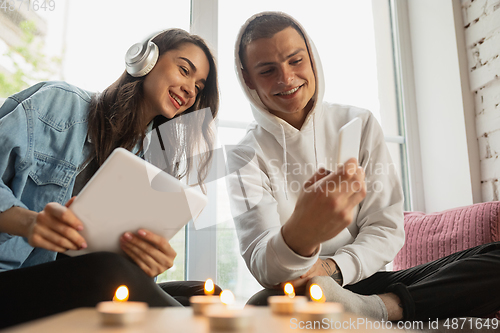 Image of Quarantine lockdown, stay home concept - young beautiful caucasian couple enjoying new lifestyle during coronavirus worldwide health emergency