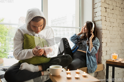 Image of Quarantine lockdown, stay home concept - young beautiful caucasian couple enjoying new lifestyle during coronavirus worldwide health emergency