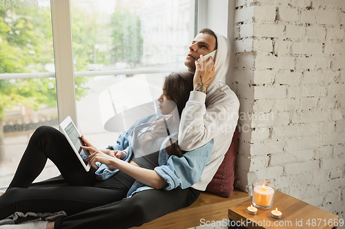 Image of Quarantine lockdown, stay home concept - young beautiful caucasian couple enjoying new lifestyle during coronavirus worldwide health emergency