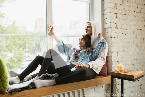 Image of Quarantine lockdown, stay home concept - young beautiful caucasian couple enjoying new lifestyle during coronavirus worldwide health emergency