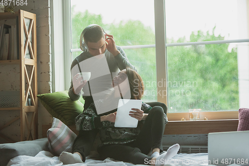 Image of Quarantine lockdown, stay home concept - young beautiful caucasian couple enjoying new lifestyle during coronavirus worldwide health emergency