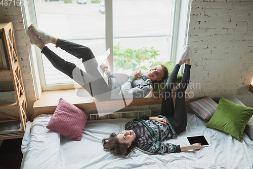 Image of Quarantine lockdown, stay home concept - young beautiful caucasian couple enjoying new lifestyle during coronavirus worldwide health emergency