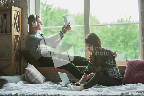 Image of Quarantine lockdown, stay home concept - young beautiful caucasian couple enjoying new lifestyle during coronavirus worldwide health emergency