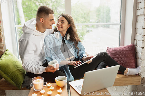 Image of Quarantine lockdown, stay home concept - young beautiful caucasian couple enjoying new lifestyle during coronavirus worldwide health emergency