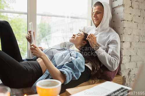 Image of Quarantine lockdown, stay home concept - young beautiful caucasian couple enjoying new lifestyle during coronavirus worldwide health emergency