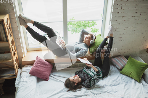 Image of Quarantine lockdown, stay home concept - young beautiful caucasian couple enjoying new lifestyle during coronavirus worldwide health emergency