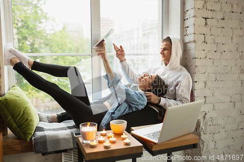 Image of Quarantine lockdown, stay home concept - young beautiful caucasian couple enjoying new lifestyle during coronavirus worldwide health emergency